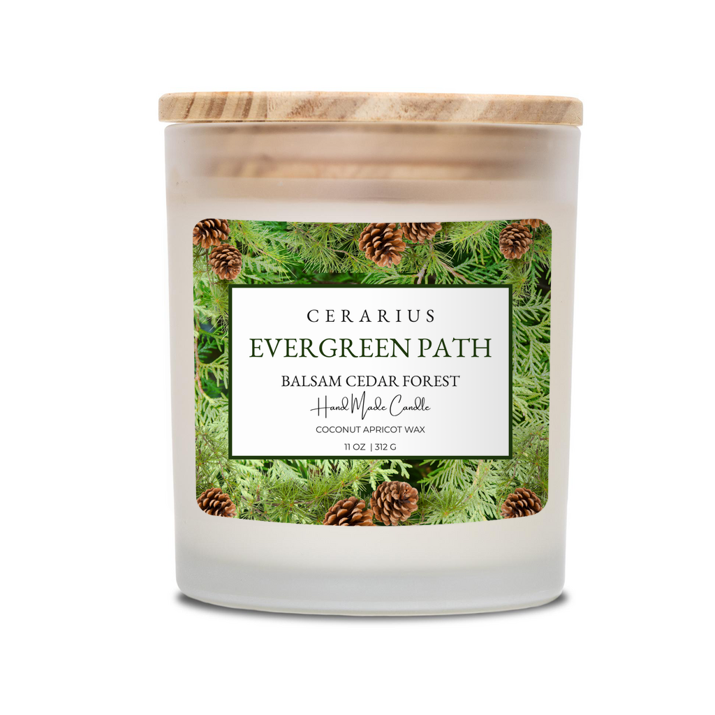 Candle with a label featuring evergreen trees and pinecones on a white background