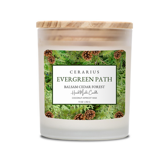 Candle with a label featuring evergreen trees and pinecones on a white background